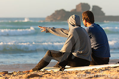 Two people sitting on the beach